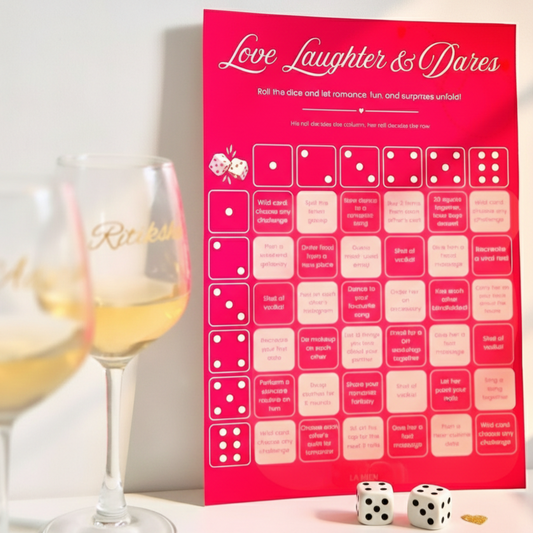 Pink game board titled 'Love Laughter & Dares' with dice and wine glasses on a light background