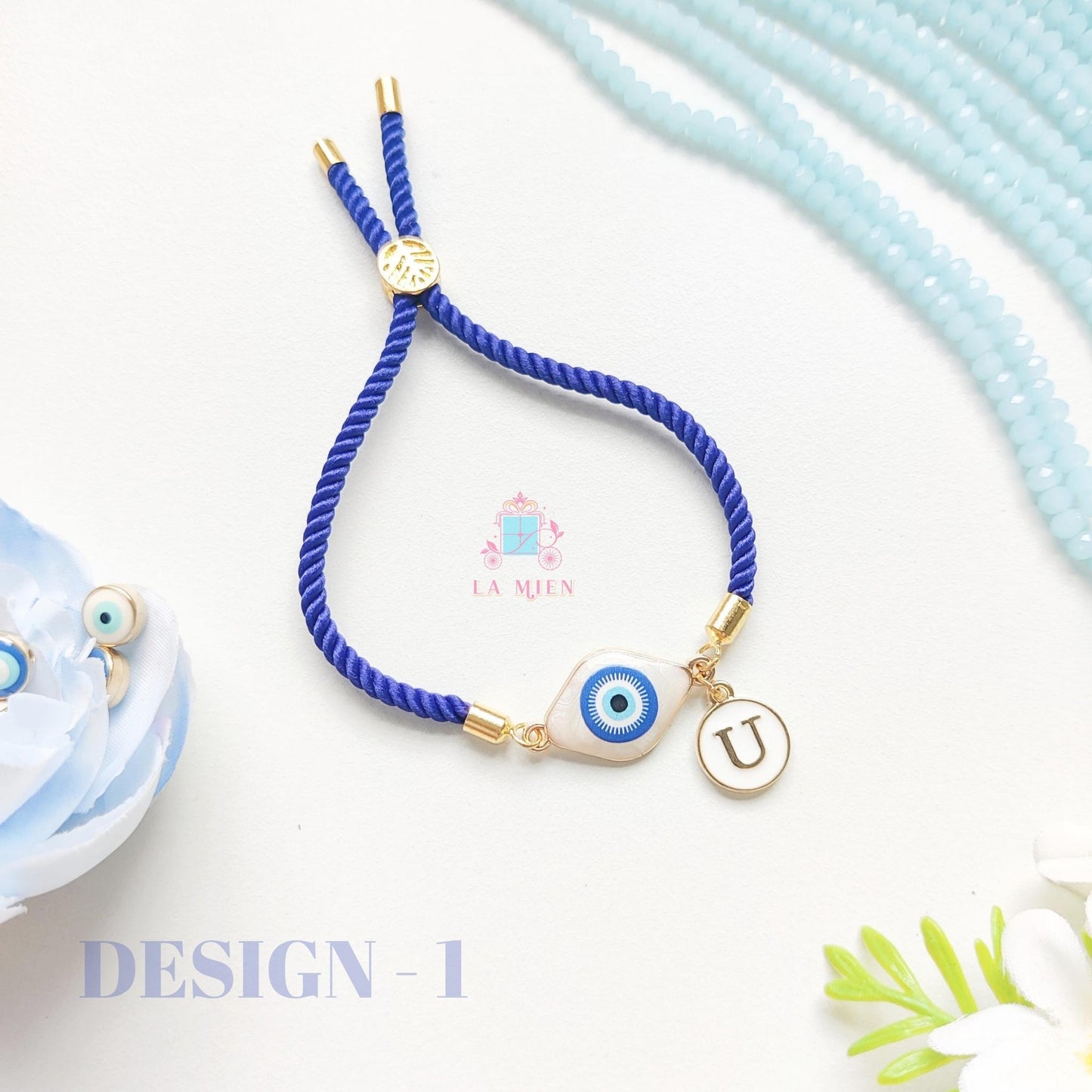 Personalized classic evil eye rakhi bracelet with initial charm and adjustable blue cord.