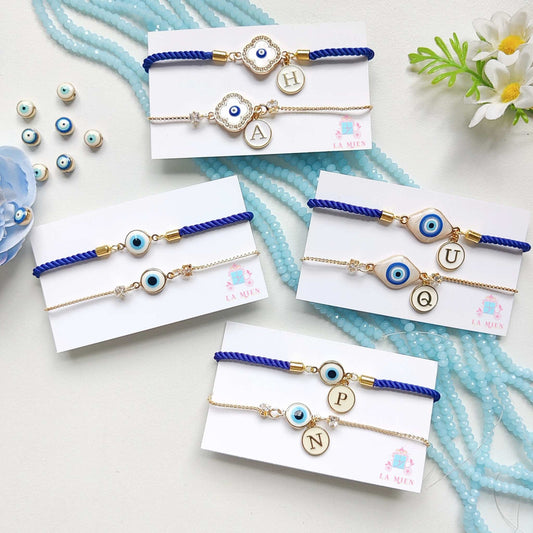 All three designs of the Personalized Bhaiya Bhabhi Evil Eye Rakhi Bracelet Set – featuring evil eye charms, custom initial tags, blue cord for Bhaiya / brother, and golden chains for Bhabhi / sister /sister-in-law