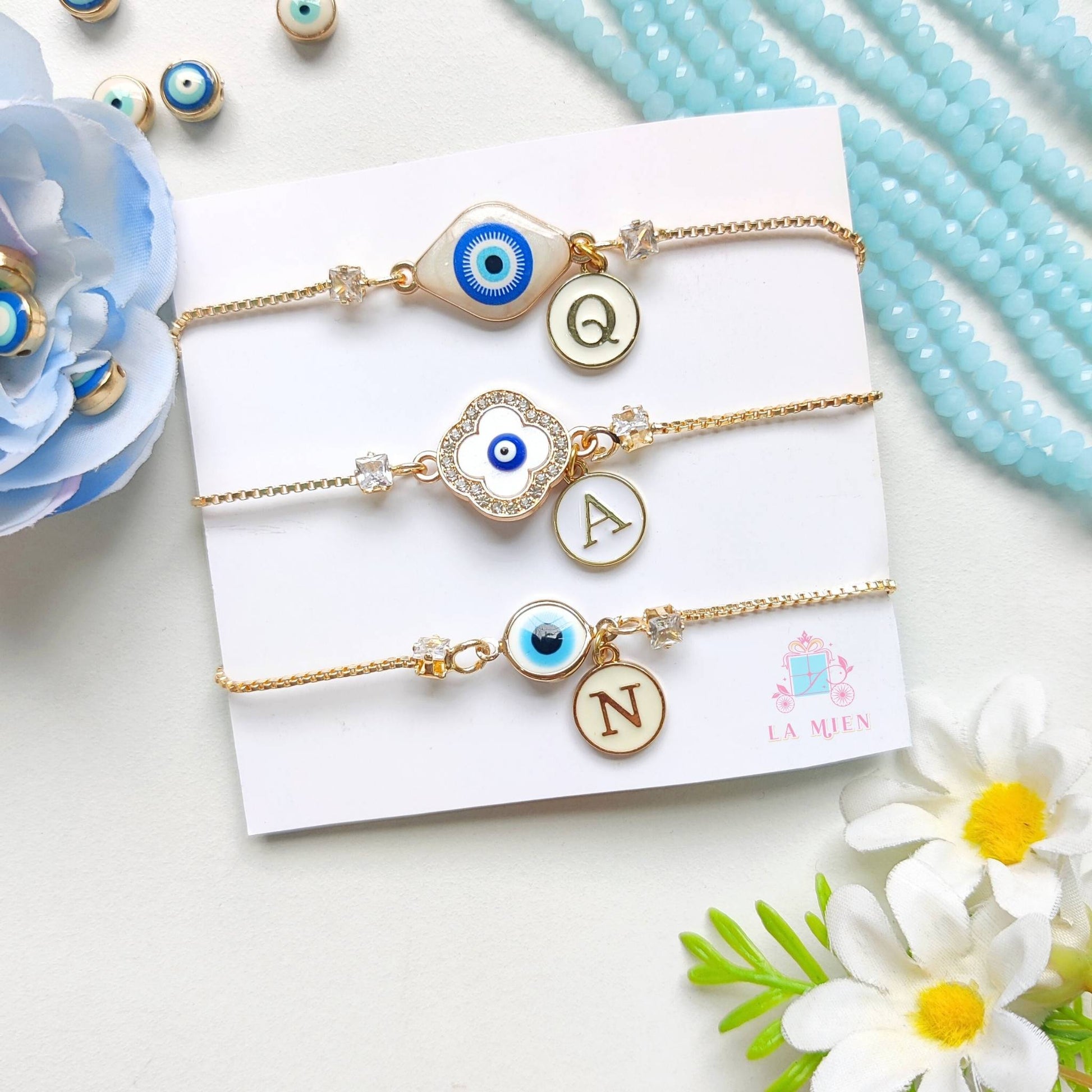 All three personalized evil eye rakhi bracelet designs with golden chains and initial charms
