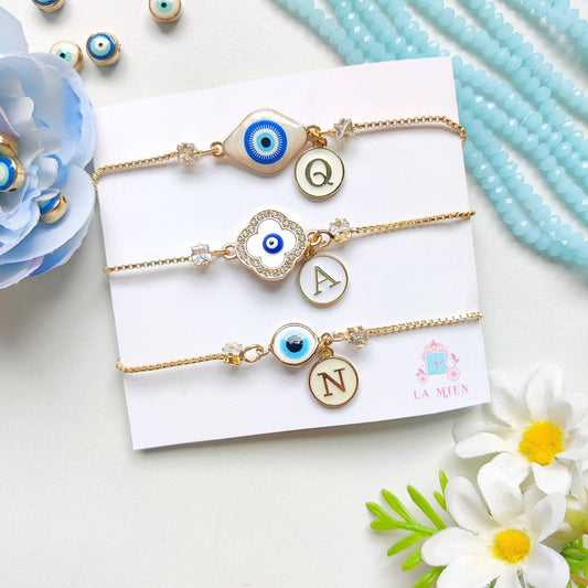 All three personalized evil eye rakhi bracelet designs with golden chains and initial charms